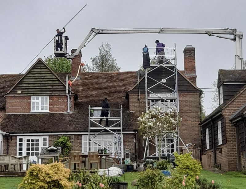 The Moss Cleaners using cherry picker and scaffolding to clean roof safely and professionally in Liss, Hampshire